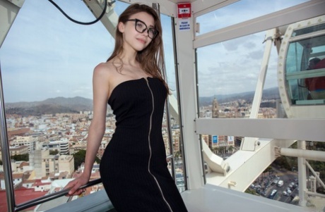 Молодая эротичная Мила в очках раздевается догола в витрине, показывая красивые сиськи 2